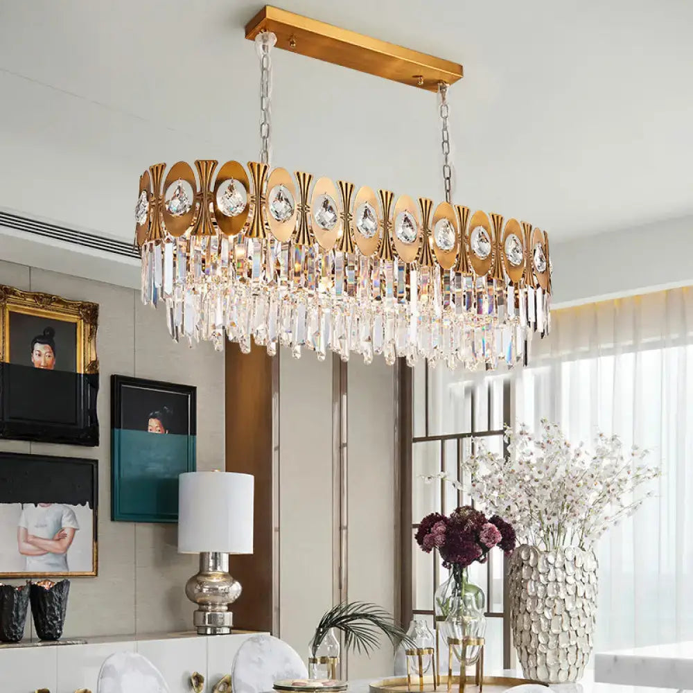Modern gold-toned rectangular island pendant light with crystal droplets and oval suspension for dining room