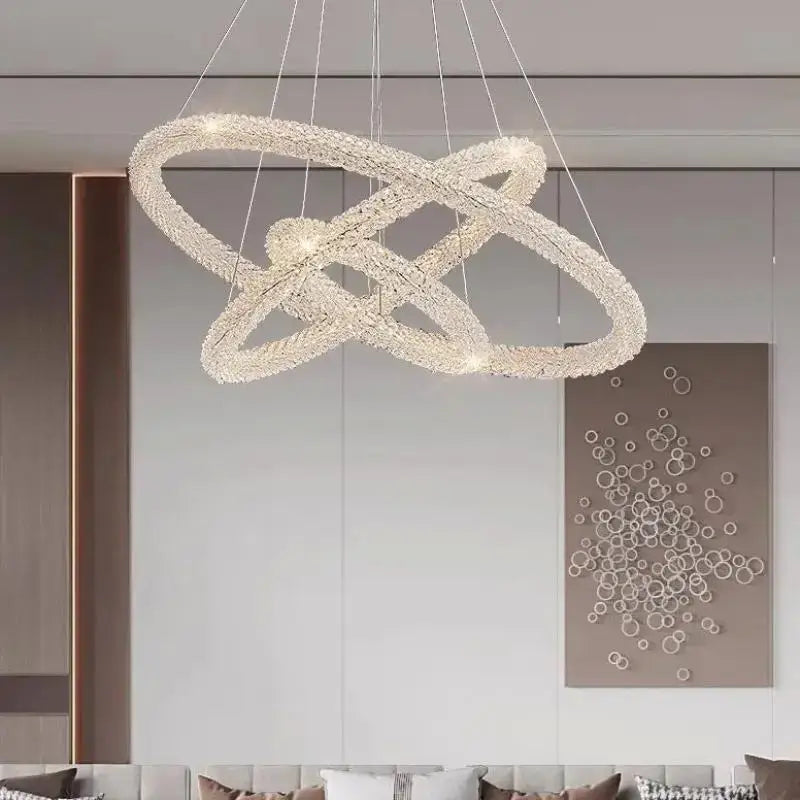 A modern gold crystal pendant light with interlocking rings suspended by thin wires for luxury dining room decorbites crystal pendant
