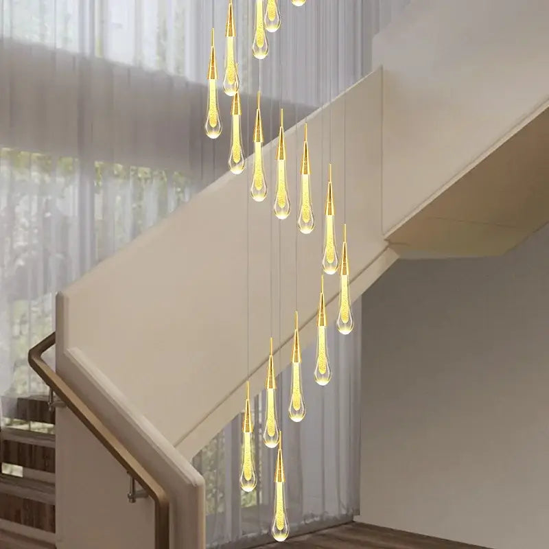 Modern gold crystal raindrop pendant lights with teardrop glass pendants and warm yellow light for foyer chandelier