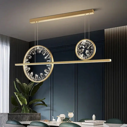 Modern gold crystal ring chandelier with two circular crystal-encrusted pendants suspended from a linear bar