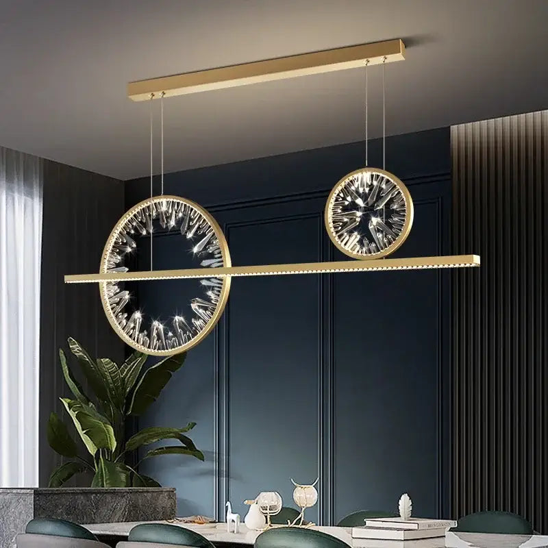 Modern gold crystal ring chandelier with two circular crystal-encrusted pendants suspended from a linear bar
