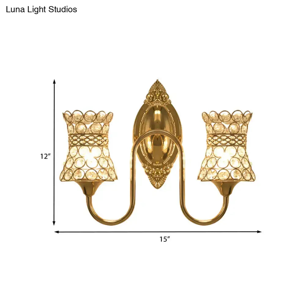 Modern gold crystal swirl wall sconce with two crystal-encrusted lampshades and ornate gold-toned central plate