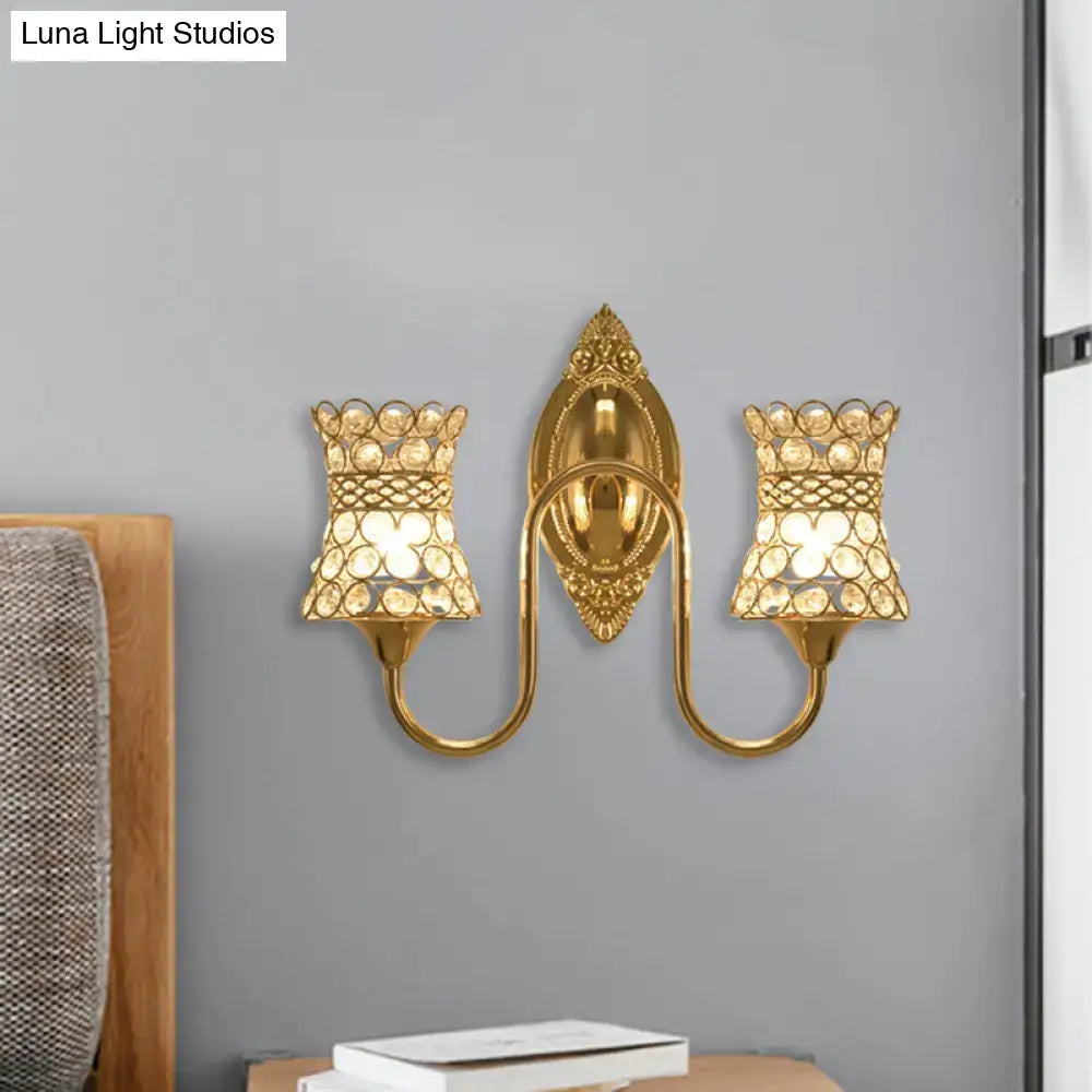 Modern gold crystal swirl wall sconce with dual crystal-adorned lampshades and ornate decorative backplate for bedroom lighting