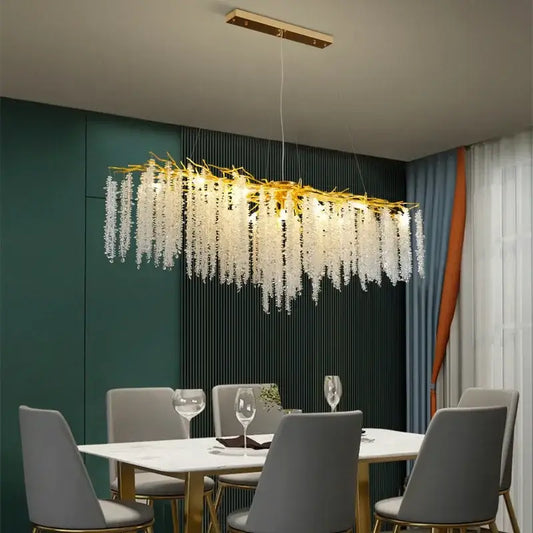 A modern gold pendant light with decorbites crystal tassel and cascading white crystal strands for dining room decor