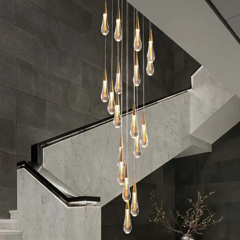 A modern gold crystal tear drop led pendant light with teardrop glass pendants and warm glowing decorbites crystal tear ceiling decor