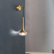 Modern gold crystal teardrop wall lamp with a gold-toned slender trumpet stem and faceted crystal shade for bedroom use