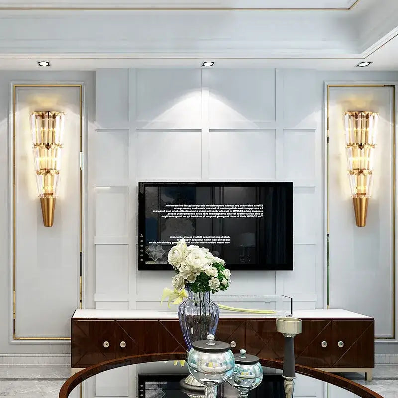 Modern gold crystal torch wall lamp with a slender blue tinted glass vase holding white roses for living room decorbites crystal torch wall