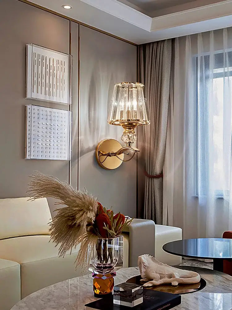 Modern gold crystal wall lamp with a faceted crystal shade and ornate curved arm for stylish bedroom decorbites crystal wall lighting