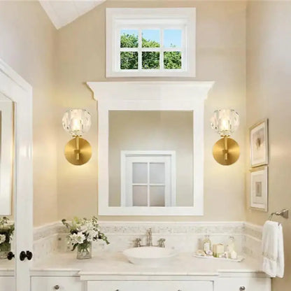 Gold finished DecorBites™ Ivy crystal wall lamps with faceted shades flank a white framed mirror in bathroom
