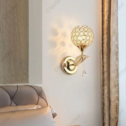 Modern gold crystal wall lamp with spherical globe and dangling teardrop crystal for elegant bedroom decorbites crystal wall use