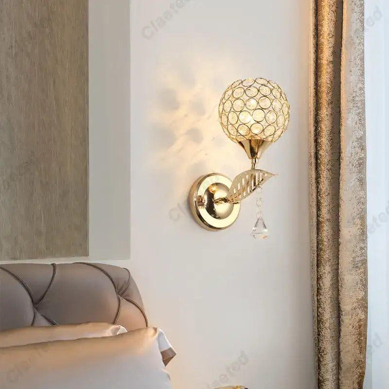 Modern gold crystal wall lamp with spherical globe and dangling teardrop crystal for elegant bedroom decorbites crystal wall use