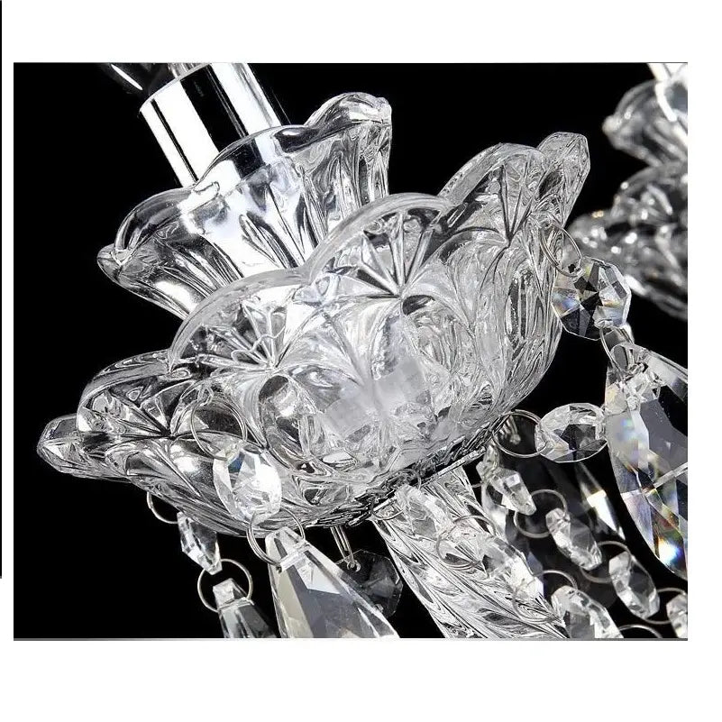 Clear crystal decorbites crystal chandelier with intricate floral cut patterns and dangling teardrop crystals in gold