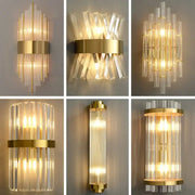 Modern gold crystal wall lamp featuring gold-toned wall sconces with clear faceted glass tubes in radial patterns