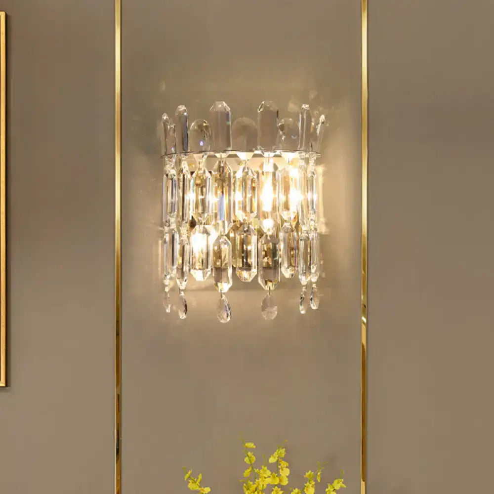 A modern gold crystal wall mount lighting sconce with a sparkling crystal frame and cascading clear crystals