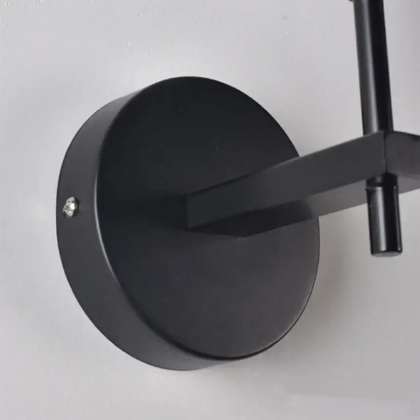 Black matte metal wall sconce with angular arm and circular base for modern gold crystal wall sconce decorbites crystal wall