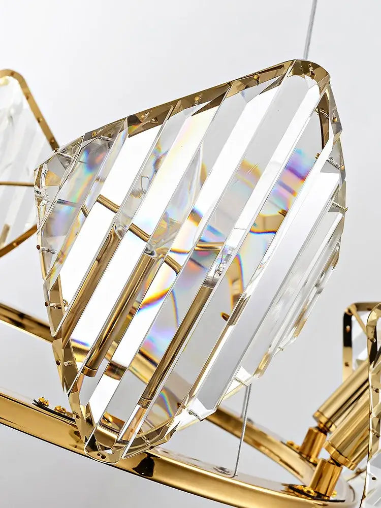 A modern gold crystal wall sconce with faceted crystal panels in a polished metal frame for luxury decorbites decor