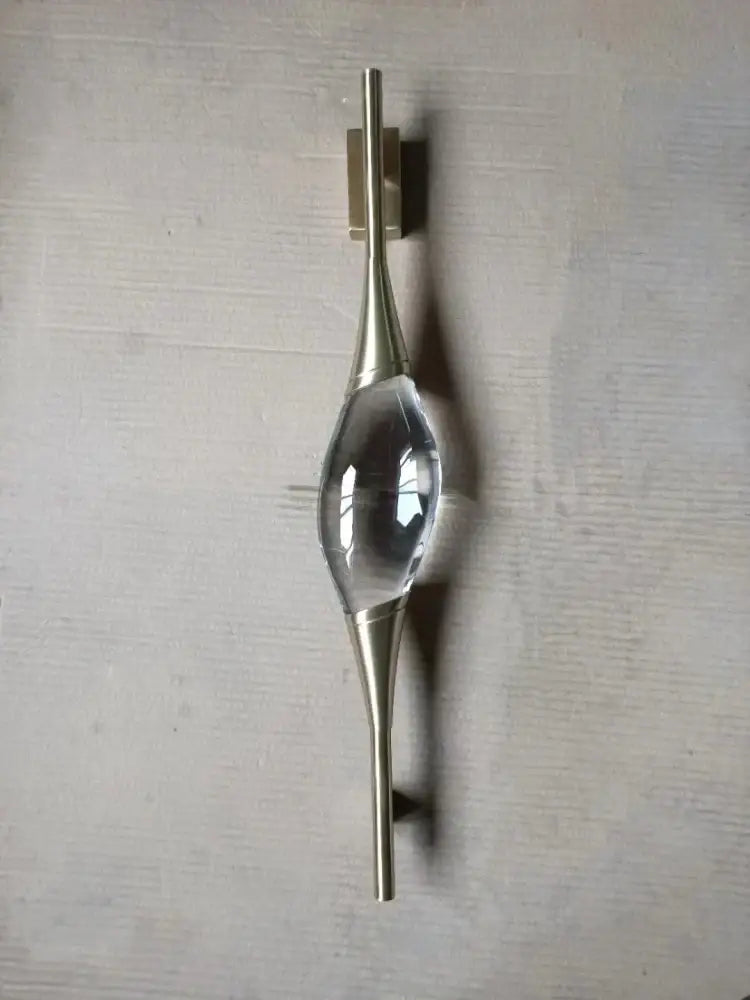 Modern gold crystal wall sconce with a brushed brass door handle and central clear crystal accent for elegant decorbites crystal wall lighting
