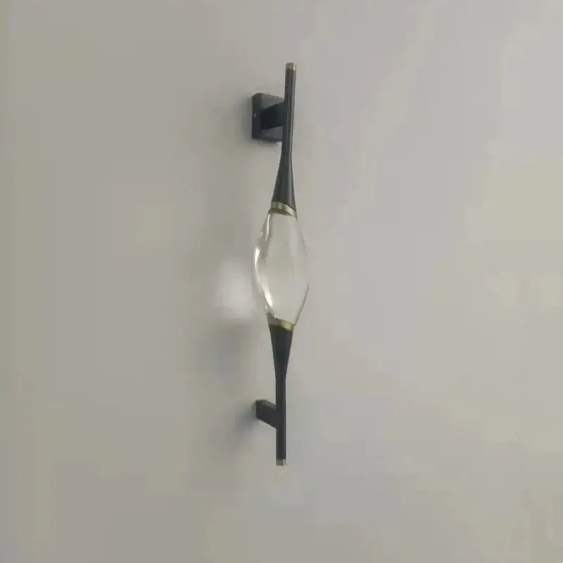 Modern gold crystal wall sconce with clear crystal centerpiece and black metal arms accented by thin gold bands for bedroom decorbites crystal wall lighting