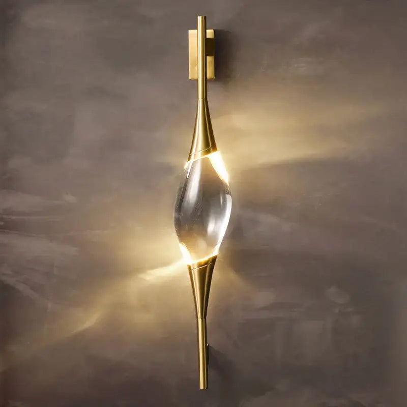 Modern gold crystal wall sconce with a clear teardrop centerpiece perfect for bedroom decorbites crystal wall lighting