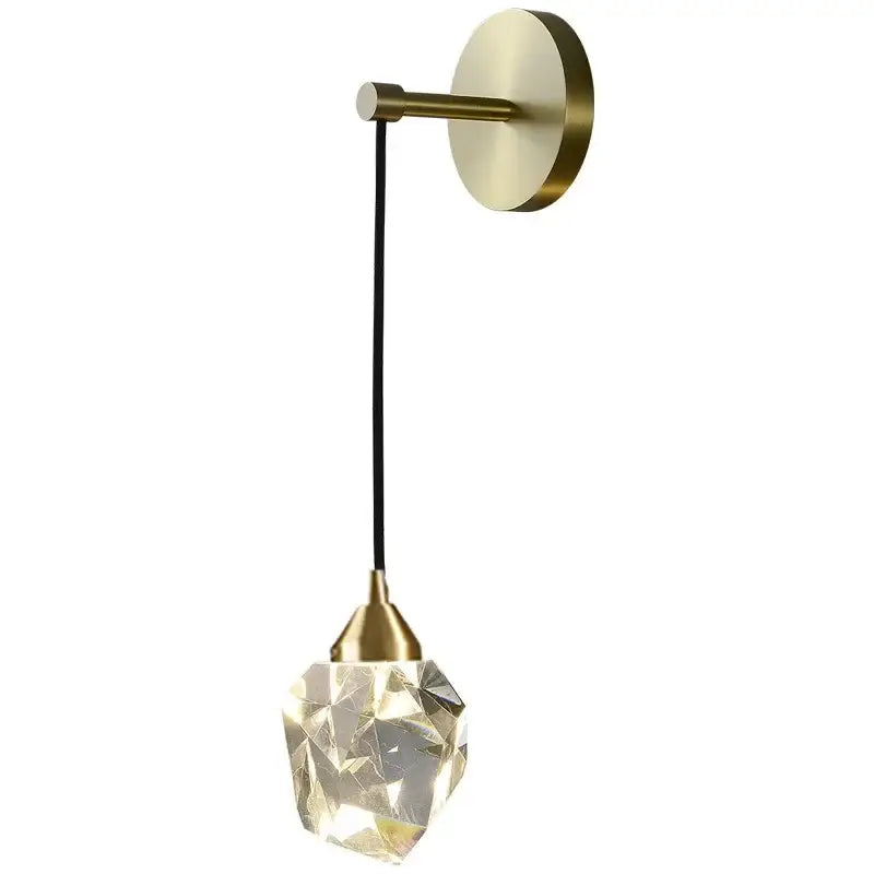 Modern gold wall sconce light with brass finish and faceted crystal pendant glowing warmly for living room use