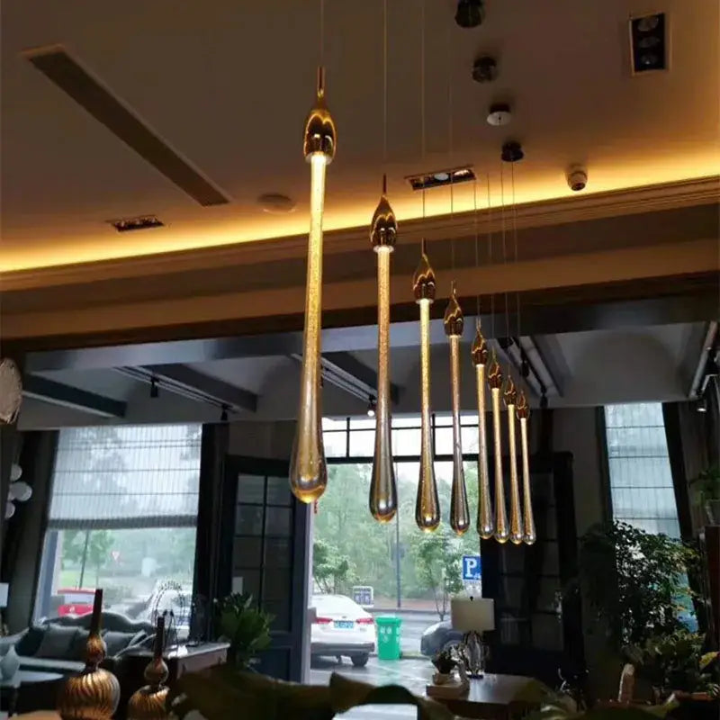 Modern gold crystal water drop pendant lights with teardrop shape and sleek design for bedroom decorbites crystal water