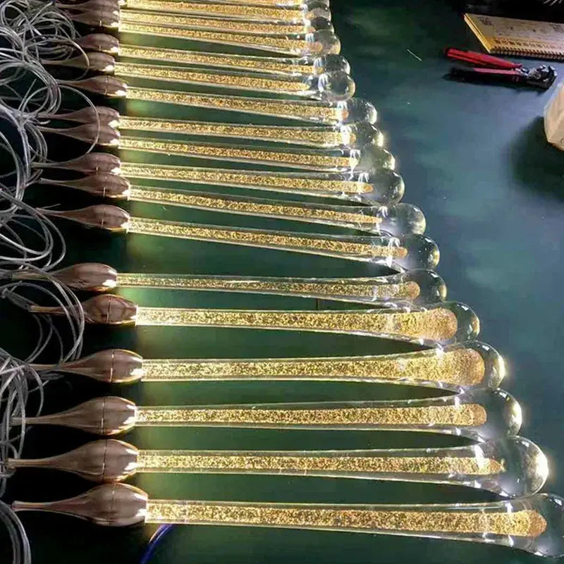 Modern gold crystal water drop chandelier pendant light featuring golden glitter-filled glass rods with bronze caps