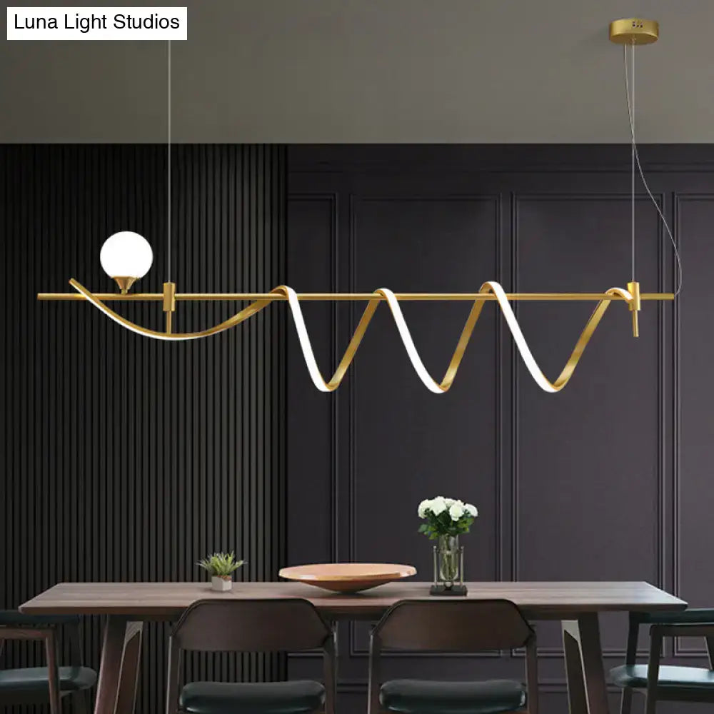 Modern gold curve island light featuring a sleek wave design with an integrated glass ball LED bulb for kitchen use