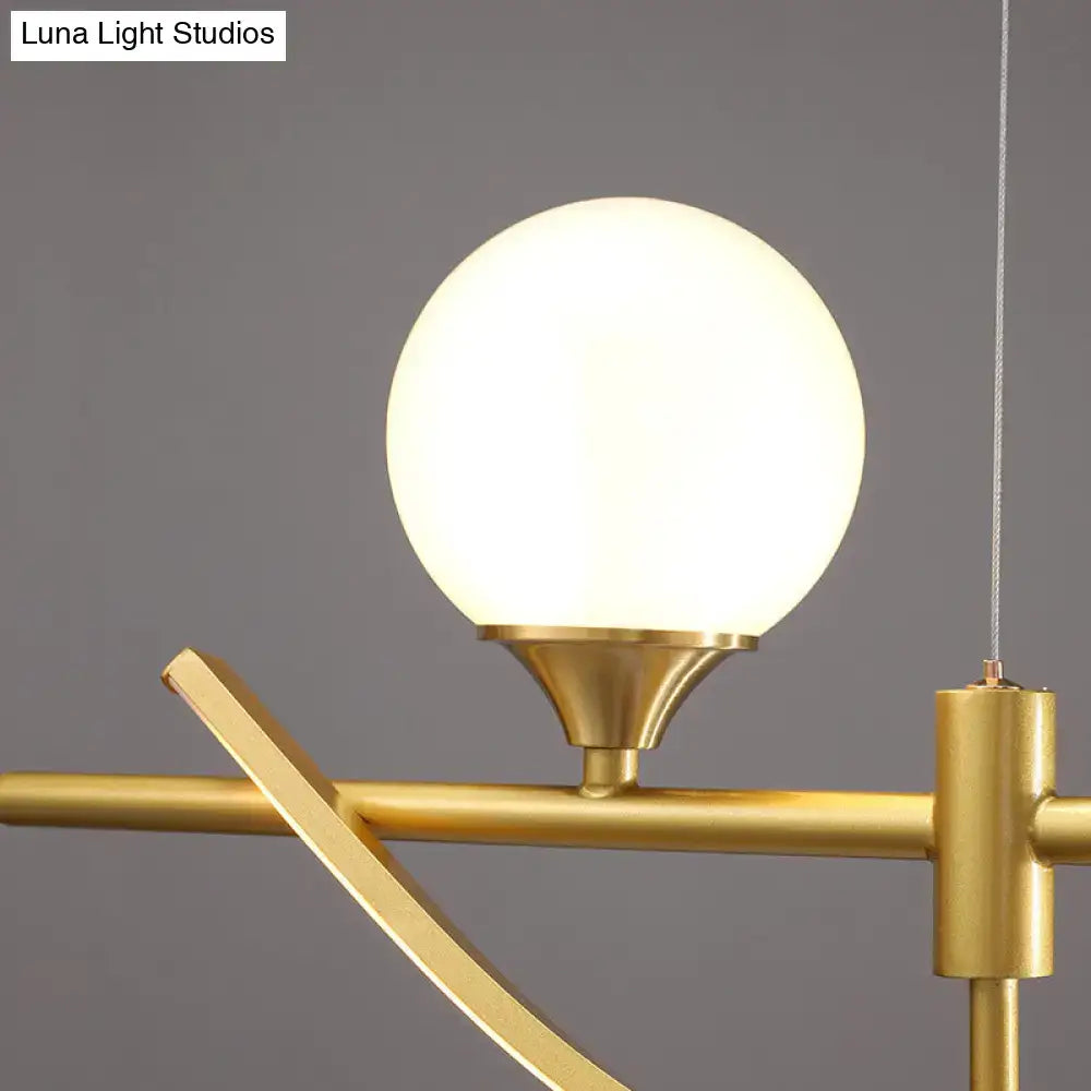 Modern gold curve island light featuring a gold-toned pendant with frosted glass globe shade as an island light fixture