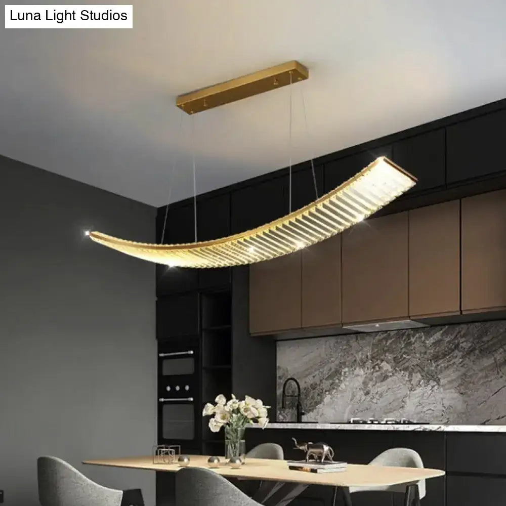Modern gold curved crystal chandelier with horizontal slats emitting warm light as a suspended crystal chandelier