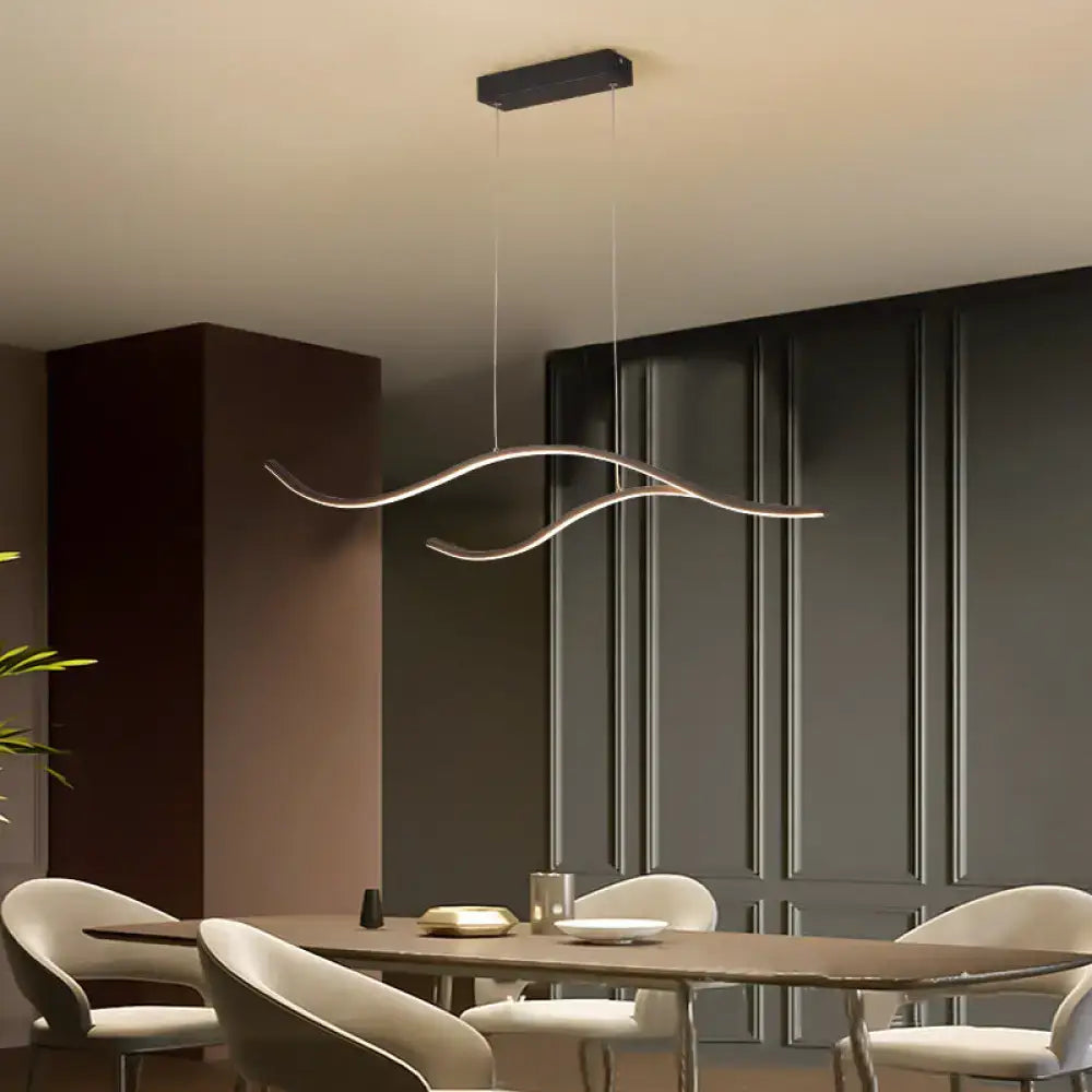 Modern silver-toned metal pendant light with sleek wave design suspended from black ceiling mount lighting fixture