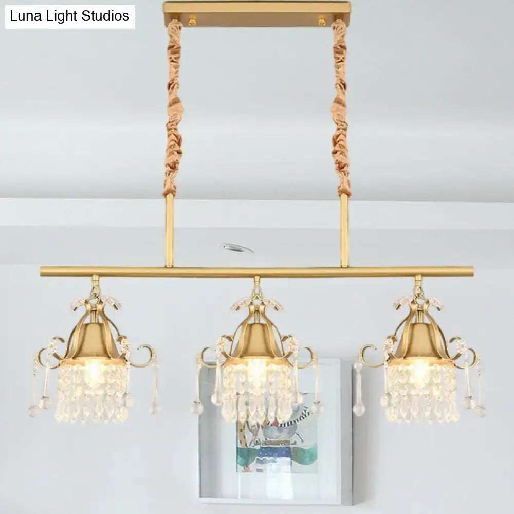 DecorBites™ crystal teardrop island pendant light with gold cylinder and three crystal-draped heads suspended by fabric cords