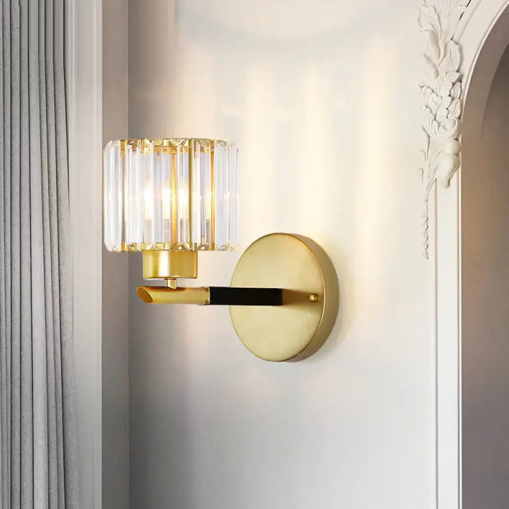 Modern gold cylinder wall light fixture with cylindrical crystal shade and black accent bar for bedroom sconce lighting