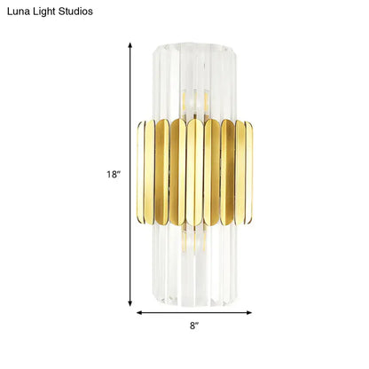 Modern gold cylinder wall mount lamp with clear faceted crystal body and horizontal metal bands for bedroom use