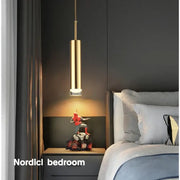 Modern gold cylindrical led pendant light with sleek design hanging above bedside table for decorbites gold modern decor