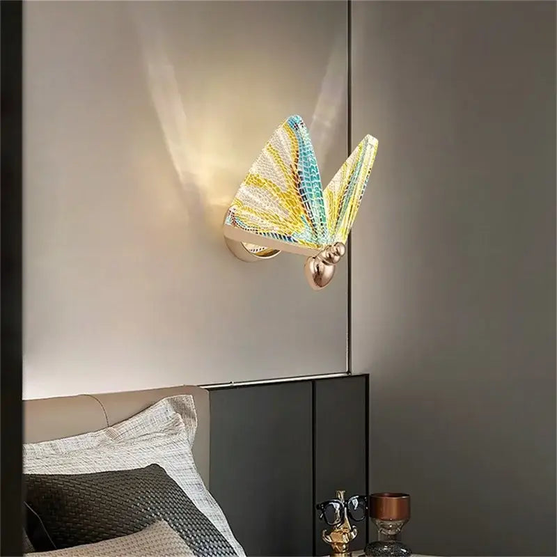 Modern gold decorbites butterfly wall sconce with iridescent yellow blue and white glass wings for bedroom lighting