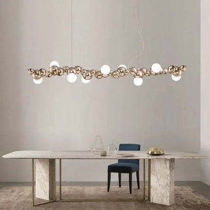 Modern gold decorbites caterpillar metal ball pendant light with polished spheres and white bulbs above marble table