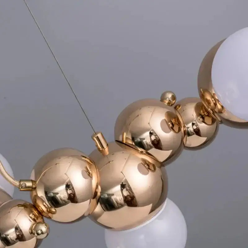 Modern gold decorbites caterpillar metal ball pendant light with reflective finish and white glass globe accents for dining room