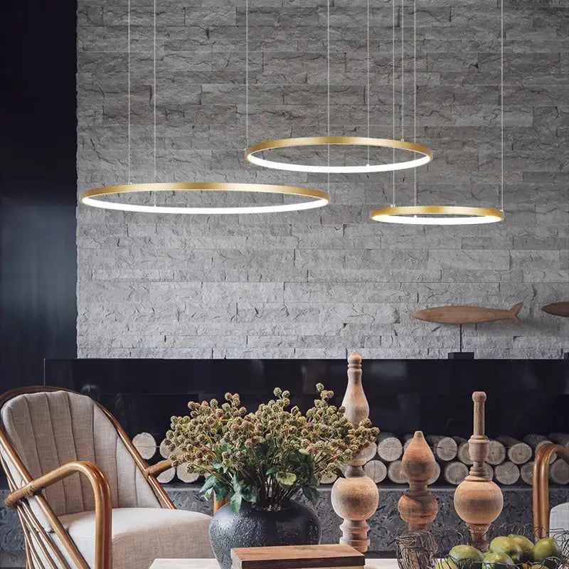 Three modern gold-finished decorbites circular led pendant lights form a circular led chandelier for dining room use