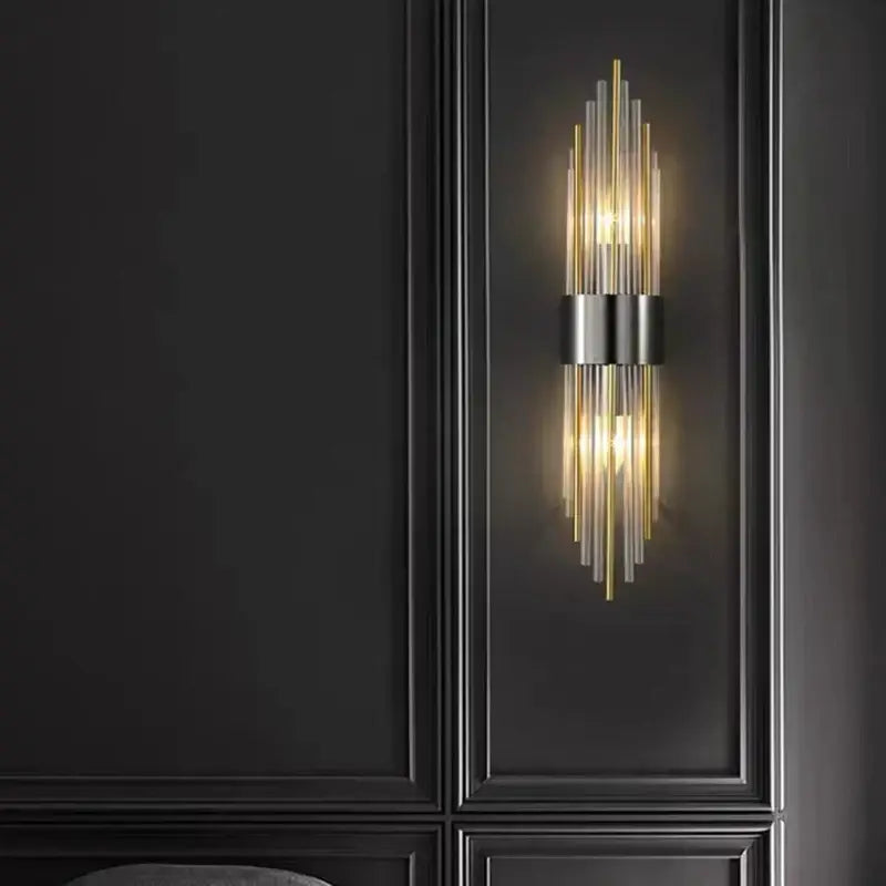 Modern wall lamp featuring decorbites clear crystal led with vertical glass rods in gold and black metal accents for bedroom