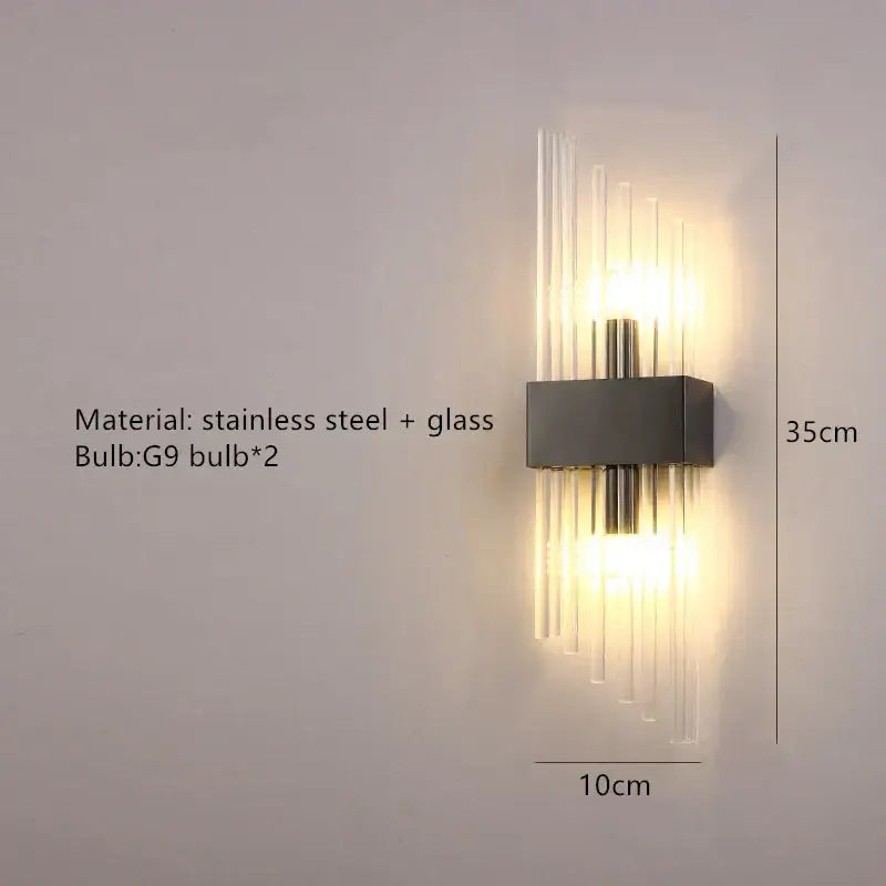Modern gold decorbites clear crystal led wall lamp with sleek stainless steel base and vertical glass rods emitting warm light