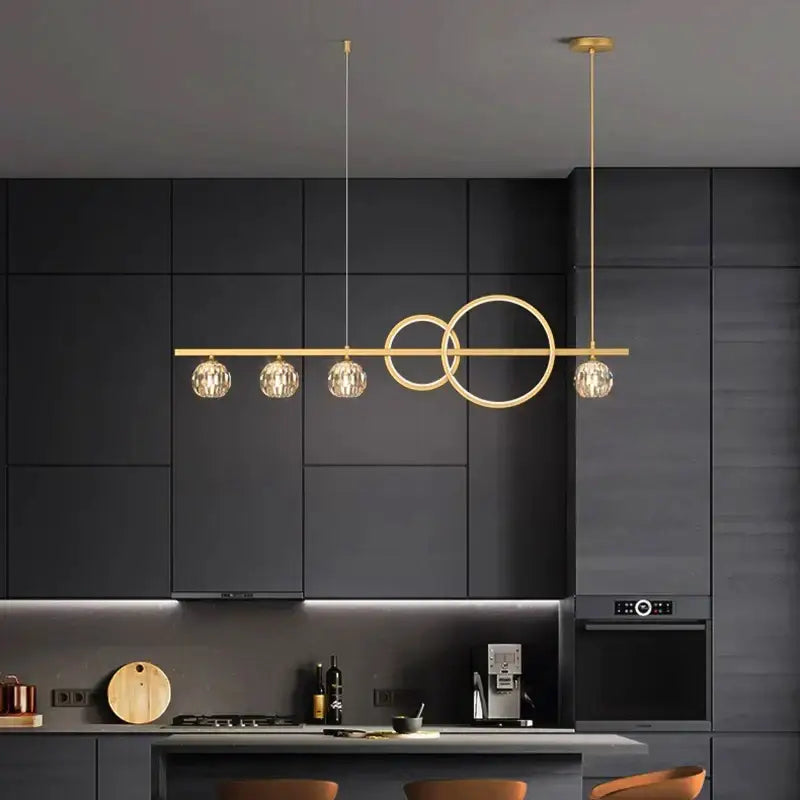 Modern gold decorbites crystal chandelier with sleek horizontal bar and faceted globe shades for dining room pendant light