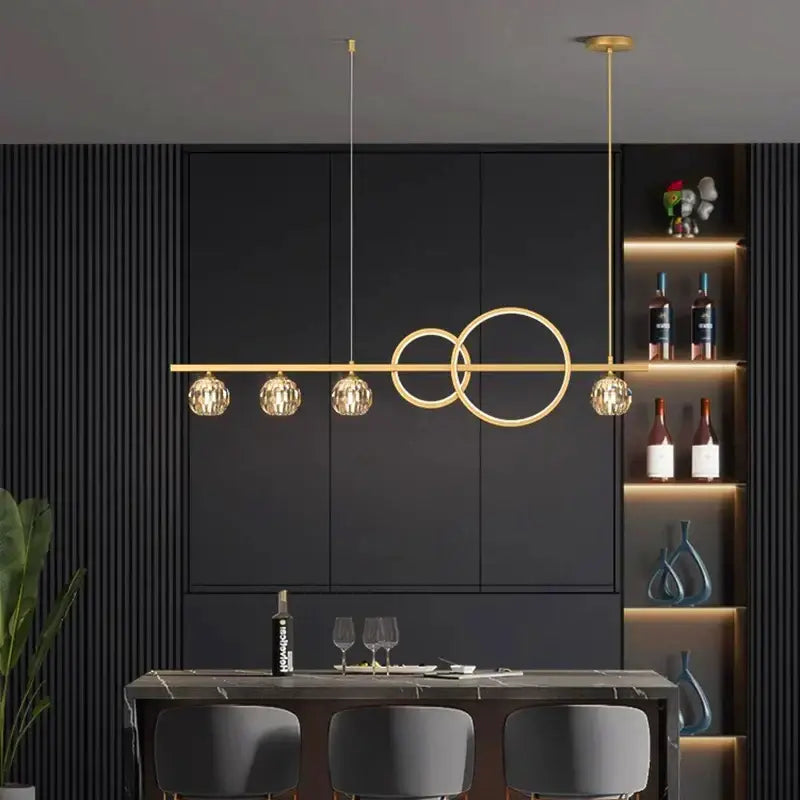 Modern gold decorbites crystal chandelier pendant light with horizontal bar, circular rings, and faceted crystal globe shades