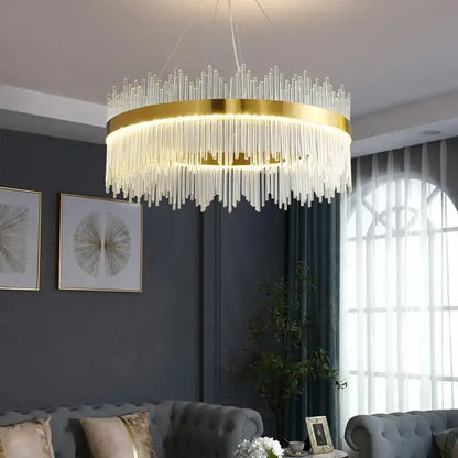 A modern gold decorbites crystal chandelier with cascading clear glass rods emitting warm light for living room use
