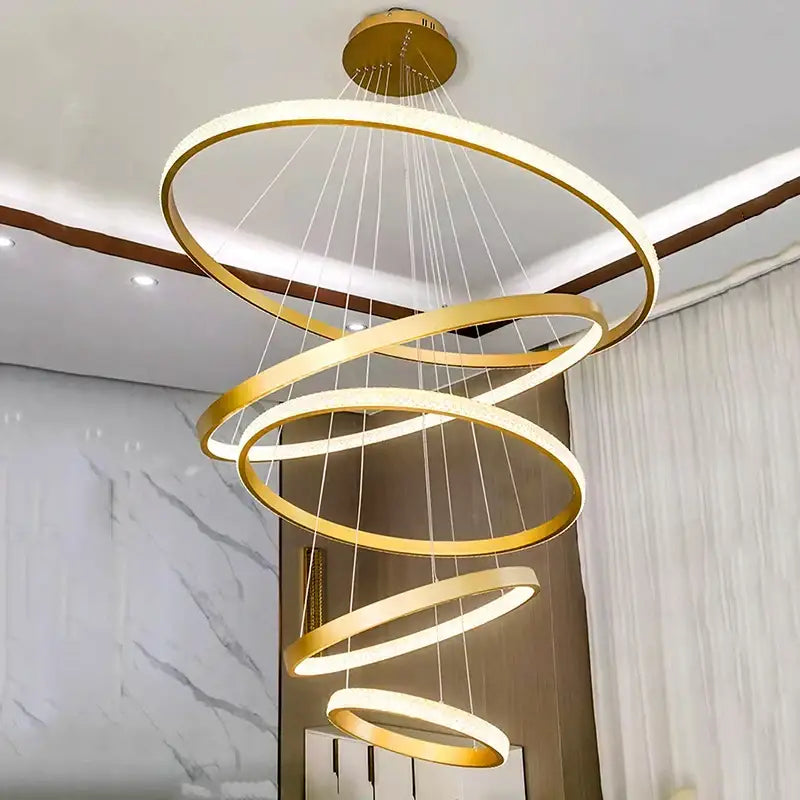 A modern gold decorbites crystal chandelier with multiple concentric rings and integrated led lighting for staircases