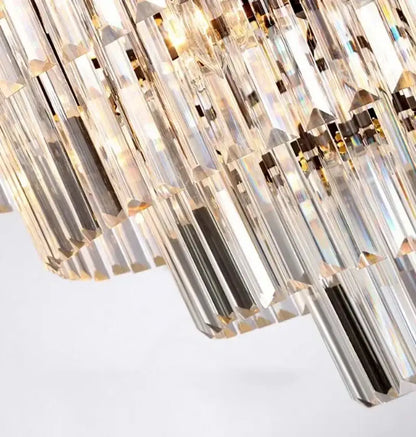 Modern gold decorbites crystal flush ceiling light with cascading clear crystal prisms refracting golden iridescent hues