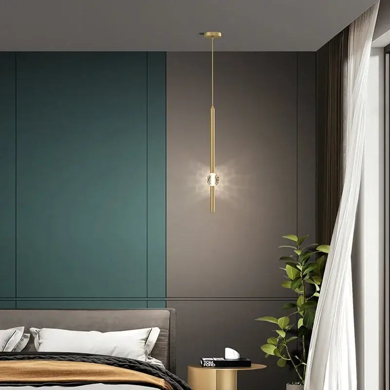 A sleek modern gold decorbites crystal led chandelier pendant light with a cylindrical body and central crystal accent
