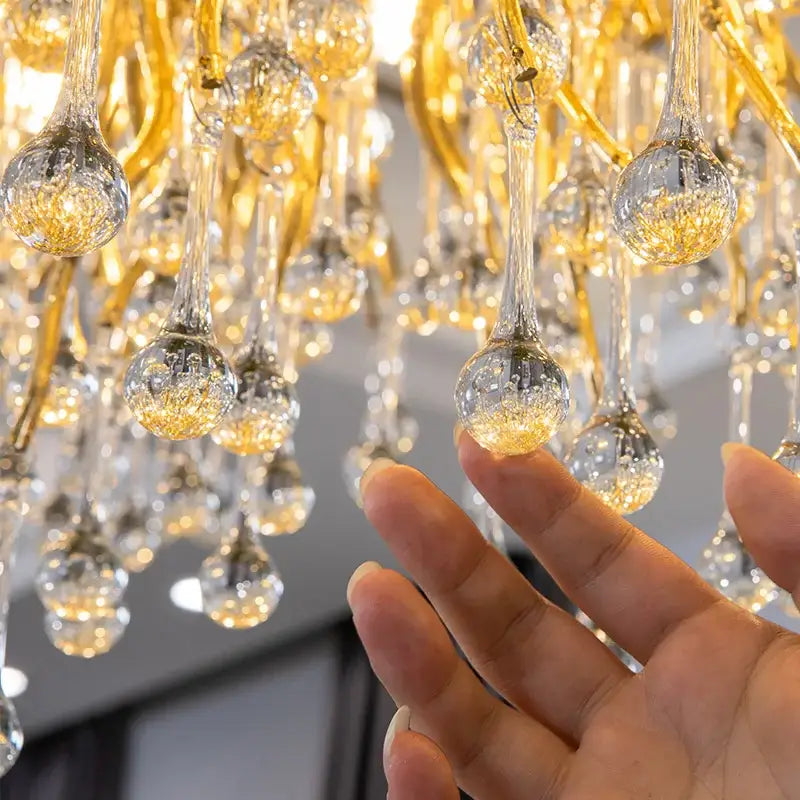 A modern gold decorbites crystal led chandelier with luxurious crystal teardrop pendants for dining room lighting