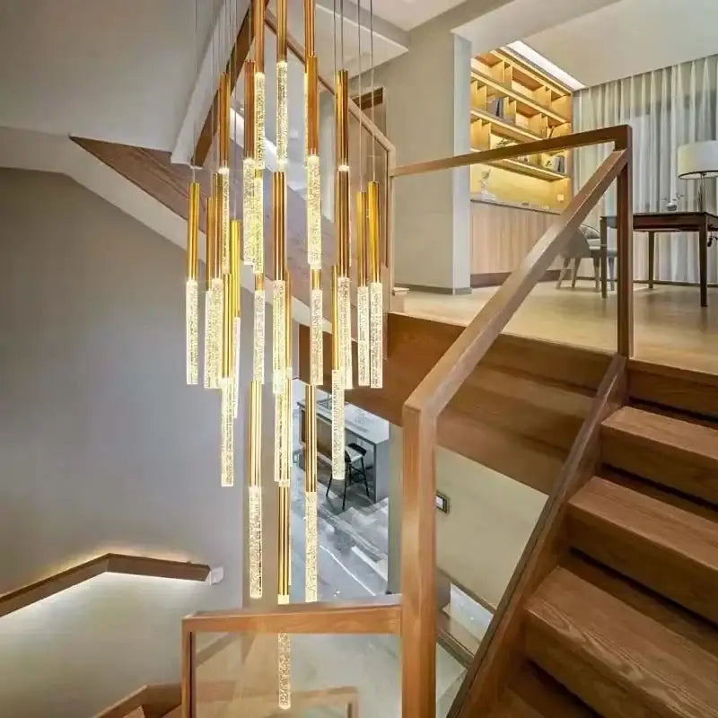 Modern gold decorbites crystal led cylindrical chandelier with sparkling crystal accents above wooden staircase lighting
