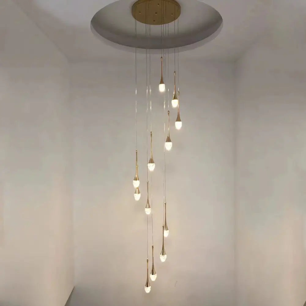 A modern gold decorbites crystal led chandelier with teardrop lights hanging from a circular ceiling mount