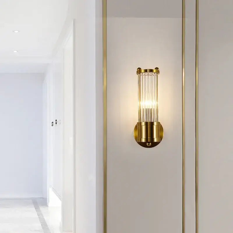 Modern gold decorbites crystal led wall lights featuring vertical glass rods and a cylindrical metal frame for bedroom sconce